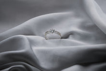 Load image into Gallery viewer, Silver ring with a diamond on a gray fabric background