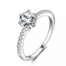 Load image into Gallery viewer, Silver ring with a large central gemstone and smaller stones on the band against a white background