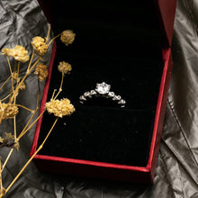 Load image into Gallery viewer, Diamond ring in a red box with dried flowers on a black surface
