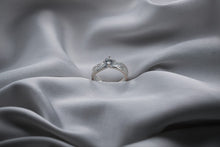 Load image into Gallery viewer, Silver ring with a diamond on a gray fabric background
