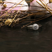 Load image into Gallery viewer, Silver ring with a diamond on a dark surface with dried flowers

