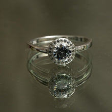 Load image into Gallery viewer, Silver ring with a diamond on a reflective surface
