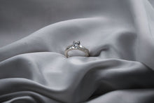 Load image into Gallery viewer, Silver ring with a diamond on a gray fabric background
